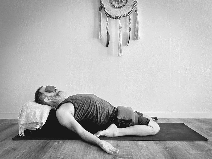 a man in supta virasana restorative yoga pose